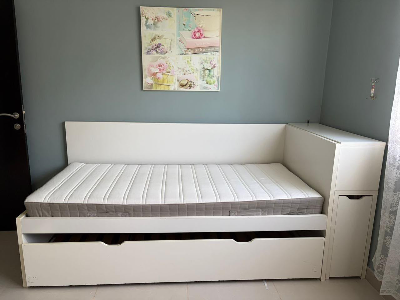 Flaxa white single bed frame with extended pull-out trundle bed and red backpanel storage headboard shelf system in Abu Dhabi