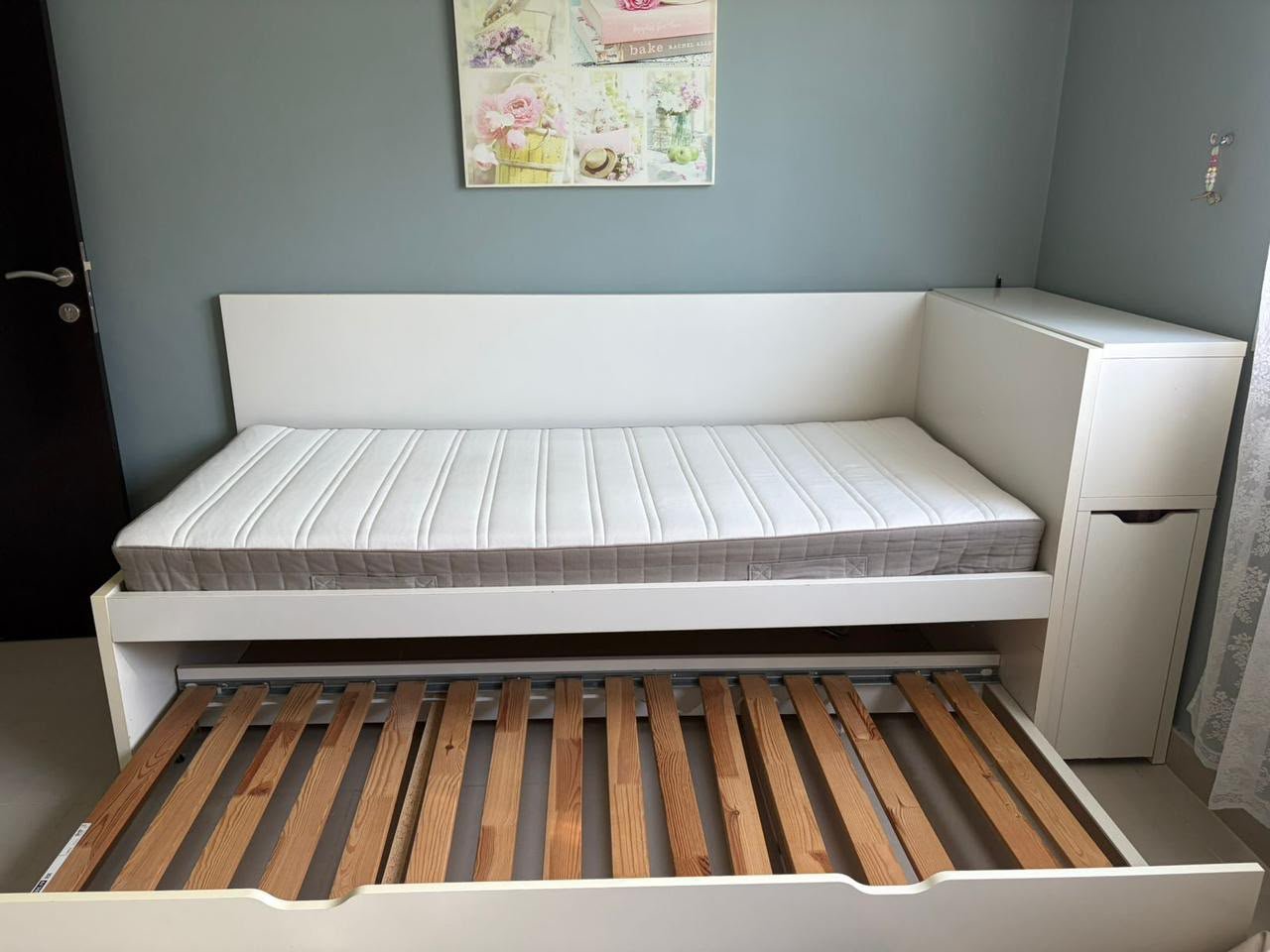 Flaxa white single bed frame with extended pull-out trundle bed and red backpanel storage headboard shelf system