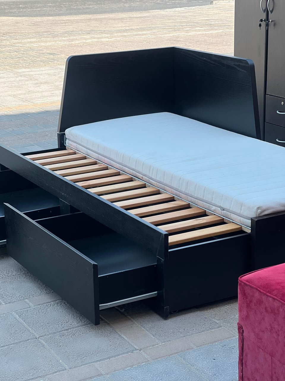 Modern black wooden used daybed frame with open storage drawers displayed at Fairy of Fortune Used Furniture Abu Dhabi
