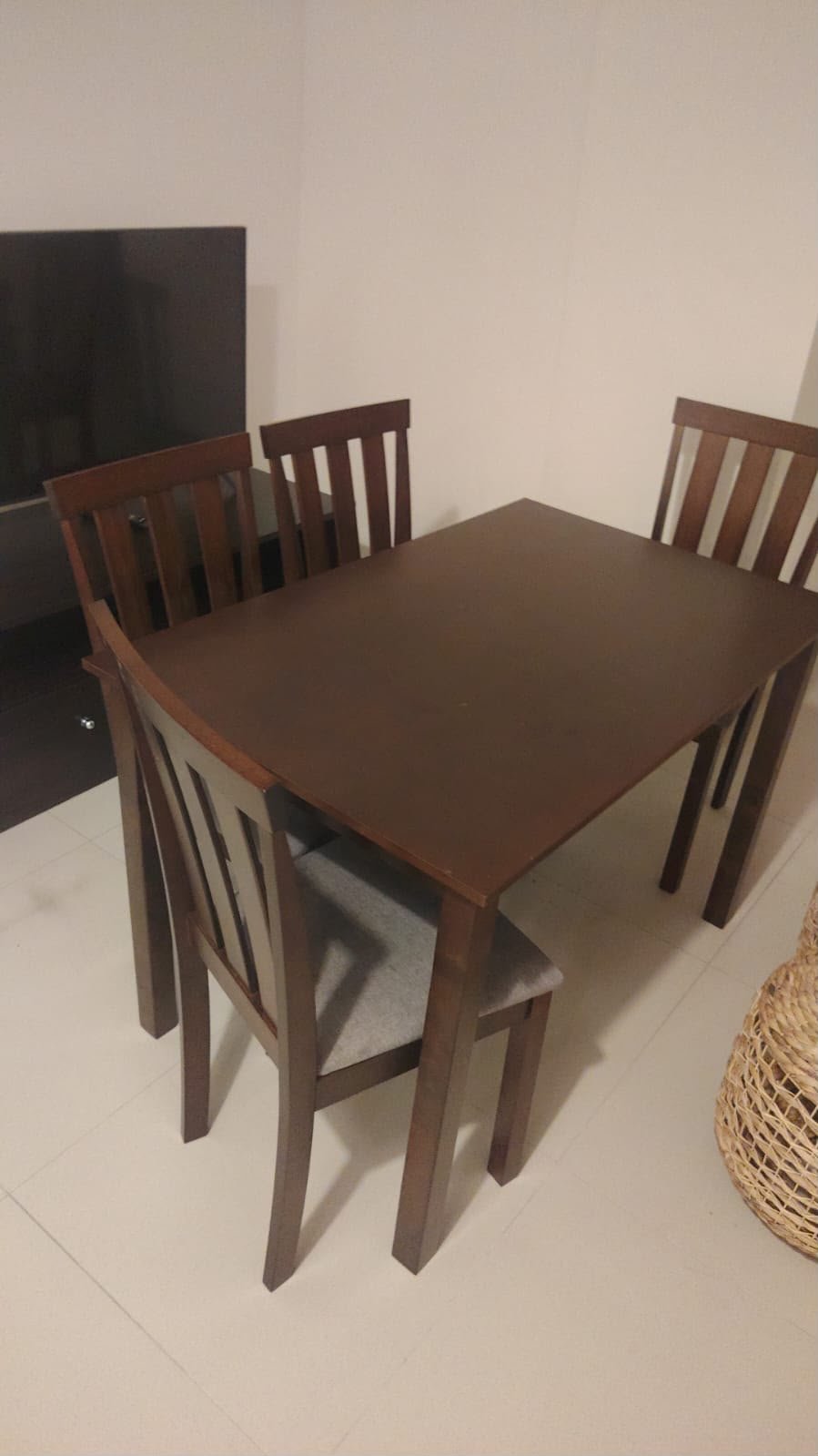 Modern dark brown wooden 4 seater used dining table set with cushioned chairs in Abu Dhabi