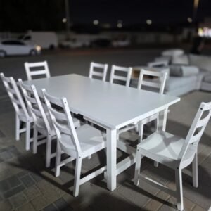 Modern white wooden 8-seater used dining table set in Abu Dhabi with ladder back chairs displayed at Fairy of Fortune store