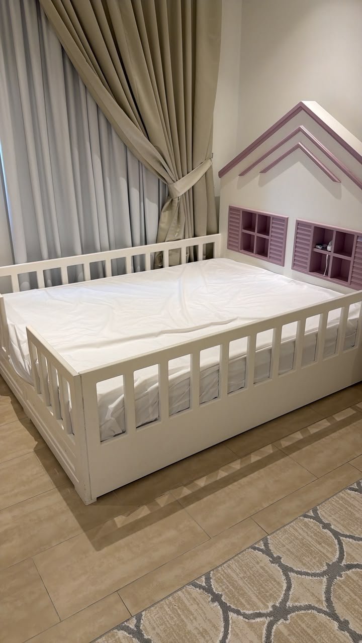 White and purple house shaped wooden used kids bed in Abu Dhabi with safety rails and window headboard shelves