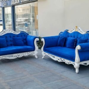 Elegant 2-piece royal blue velvet sofa set with intricate carved white wooden frames and matching accent cushions at Fairy of Fortune Used Furniture Abu Dhabi