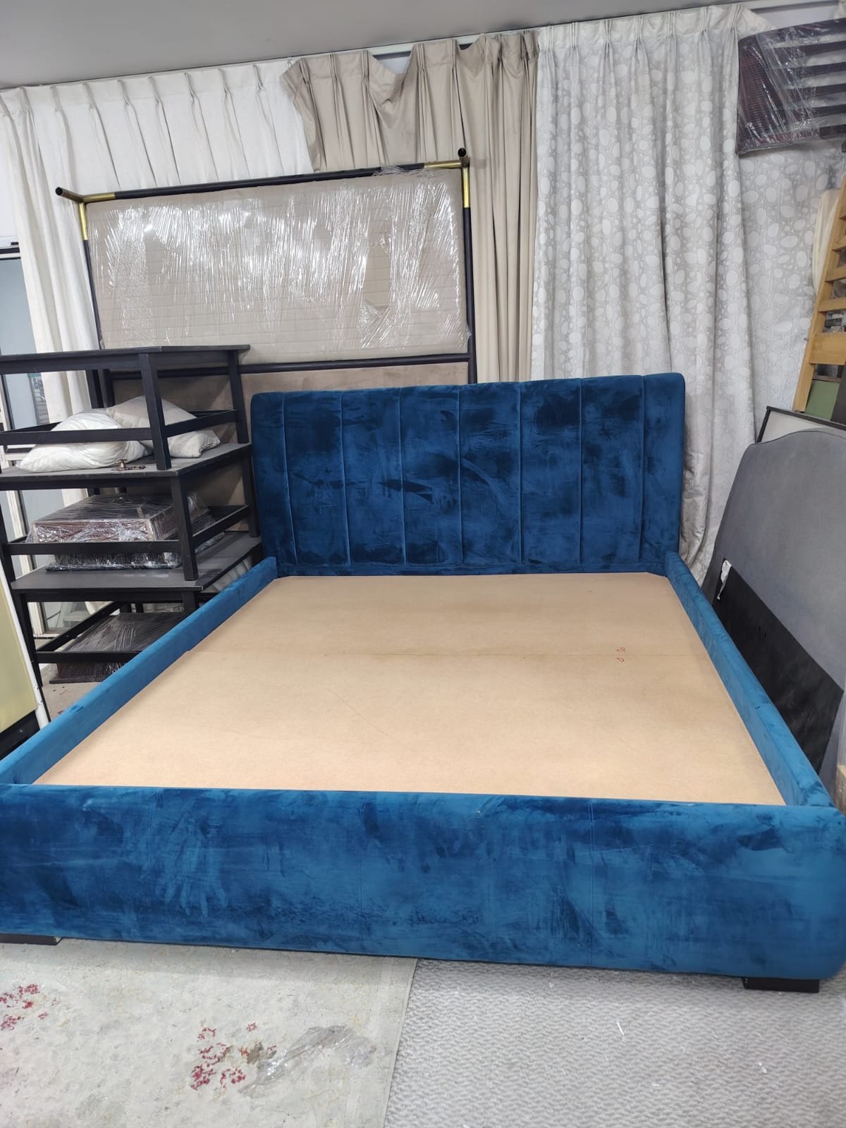 Luxury royal blue velvet upholstered double bed frame featuring a vertical channel-tufted headboard and thick comfortable mattress