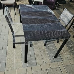 Modern dark wood rectangular 2-seater dining table wrapped for protection with two matching cushioned chairs at Fairy of Fortune Used Furniture Abu Dhabi